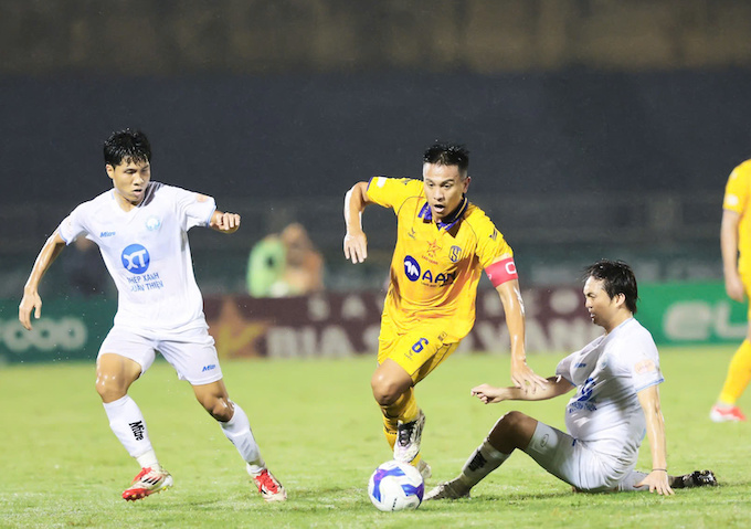 Đình Đồng (áo vàng) và SLNA đang hối hả đua trụ hạng. Ảnh: Đức Cường